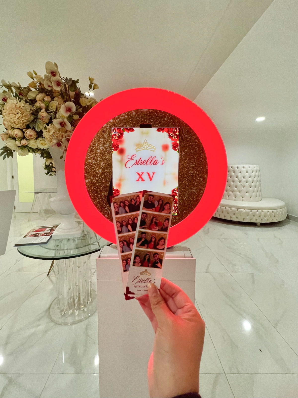 Red ring-light photo booth with printed strips at Estrella's quinceañera